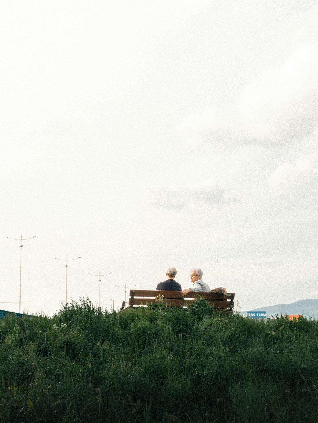 Elderly Croatian couple smiling warmly while sitting on a bench